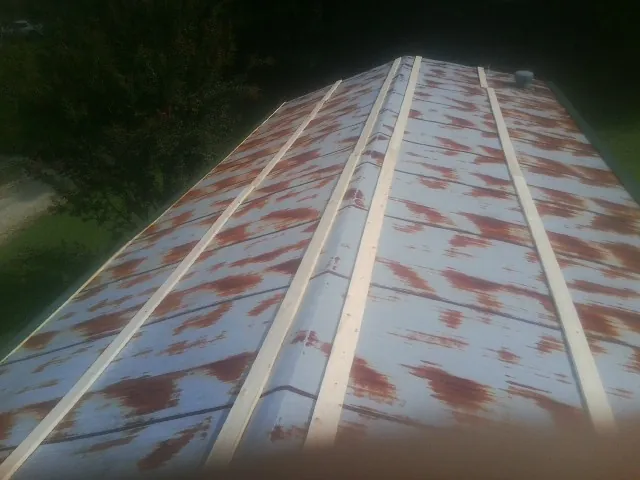Rusted metal roof panels with new wood purlins before replacement — Storm Damage Roof Repair in Delong by Roofing Brothers