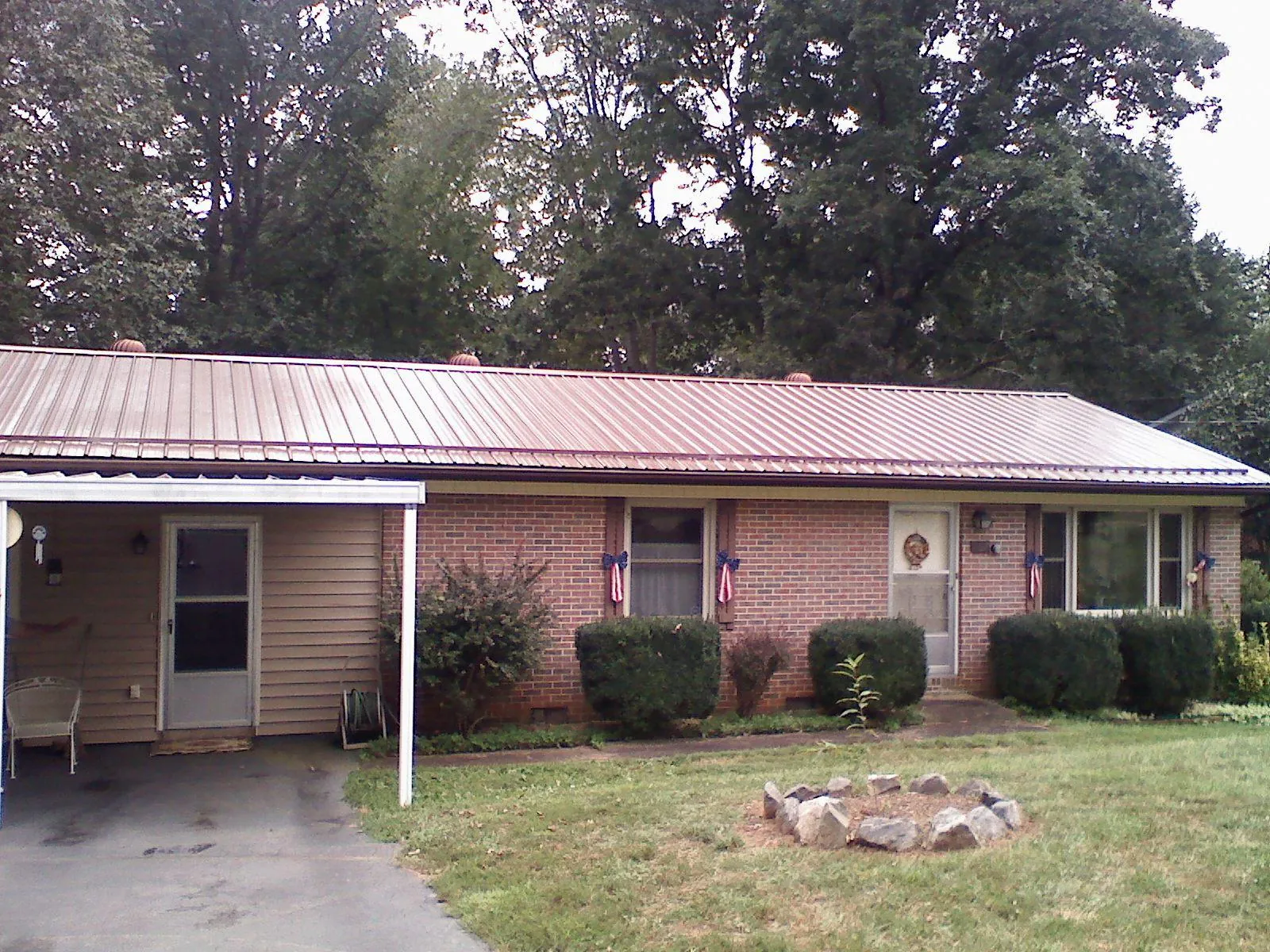 Bronze metal roof and carport on a brick ranch home — Roof Repair work by our crew in Delong
